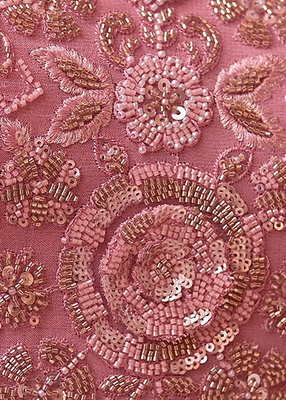 Close-up of pink embroidered anarkali with floral and paisley patterns, featuring pink sequins, beads, and metallic gold thread detailing.