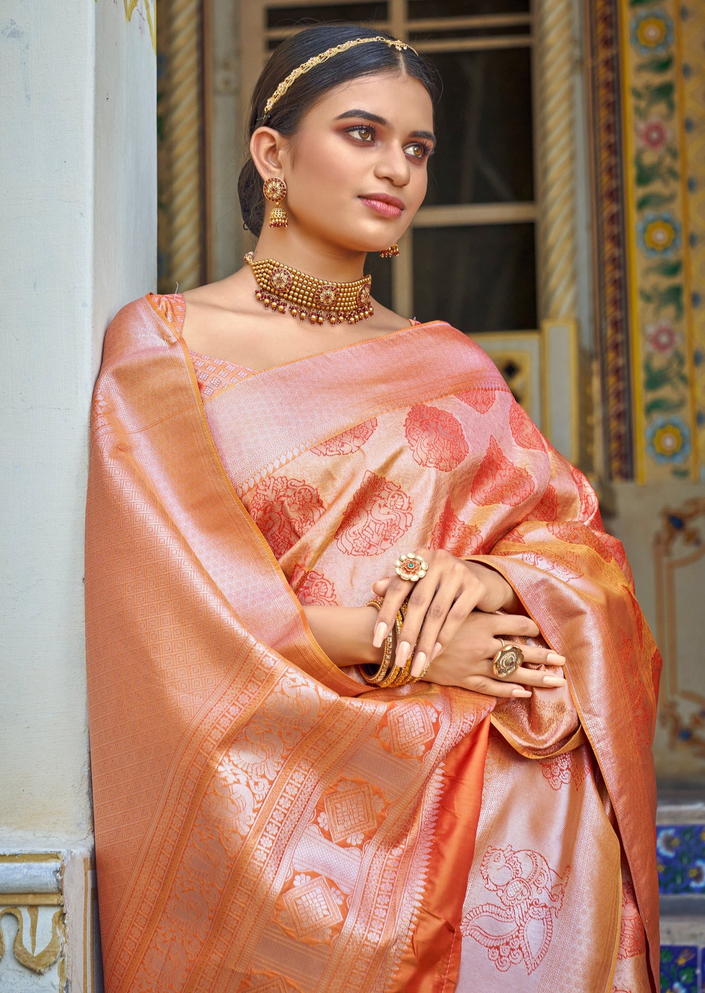 Woman in peach saree wearing traditional gold jewelry