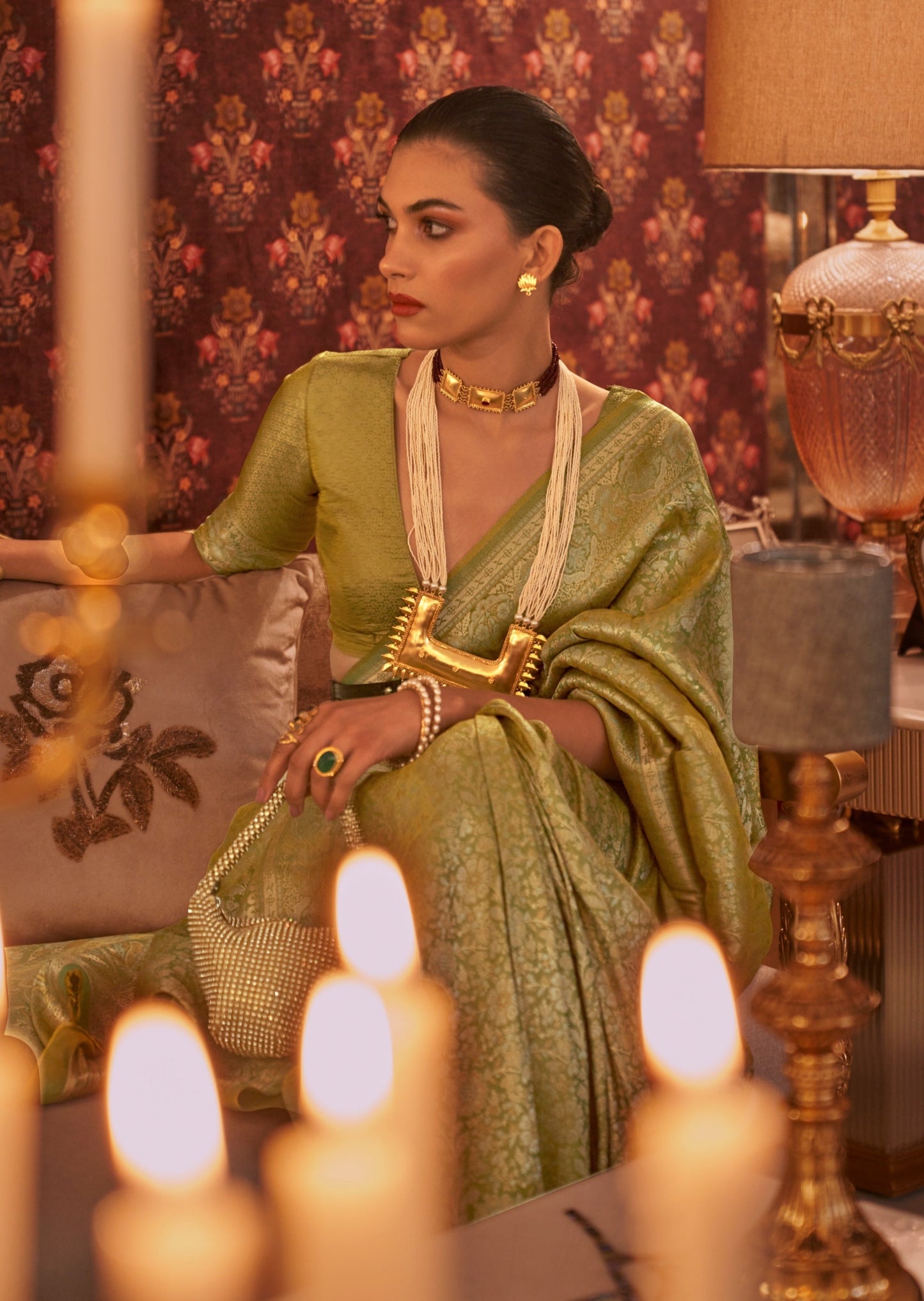 Woman sitting behind candles wearing Pure Banarasi Silk Parrot Green Handloom Bridal Saree