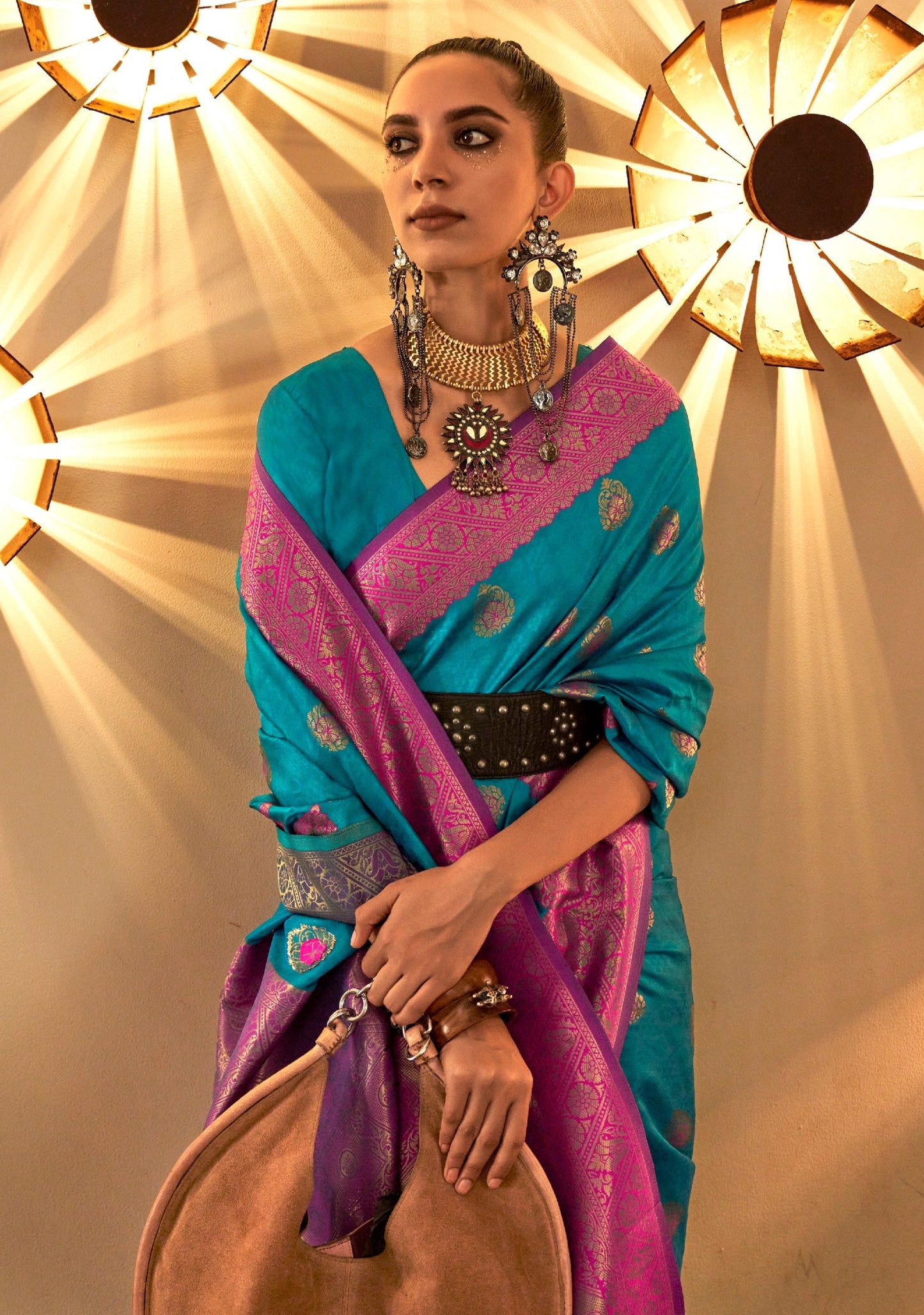 Women's blue banarasi silk saree with pink border pallu.