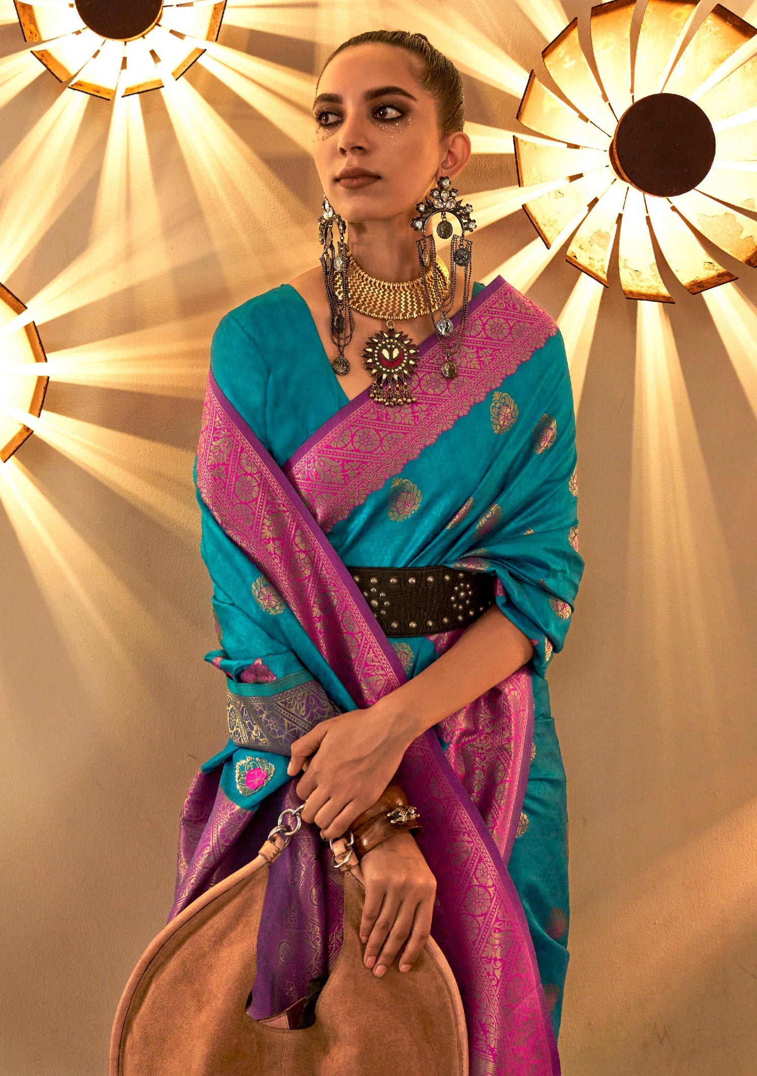 Women's blue banarasi silk saree with pink border pallu.