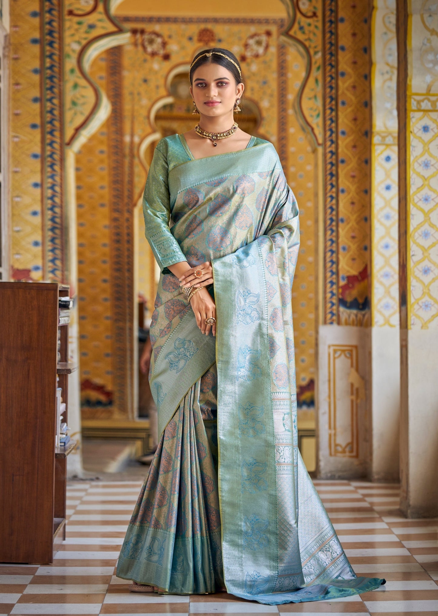 Woman standing in light blue Kanchipuram saree