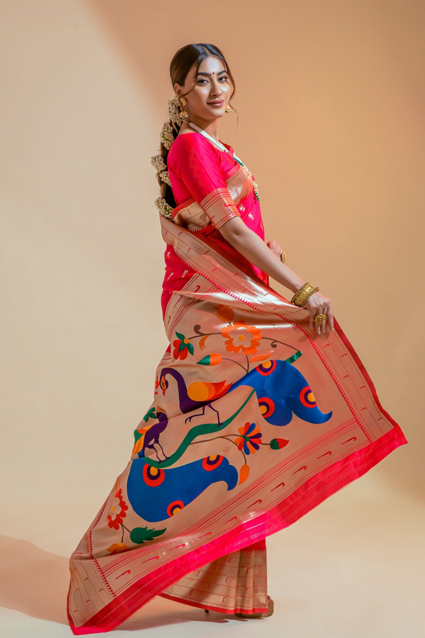 Indian woman displaying pure paithani silk red handloom bridal saree online pallu design featuring two big peacocks.