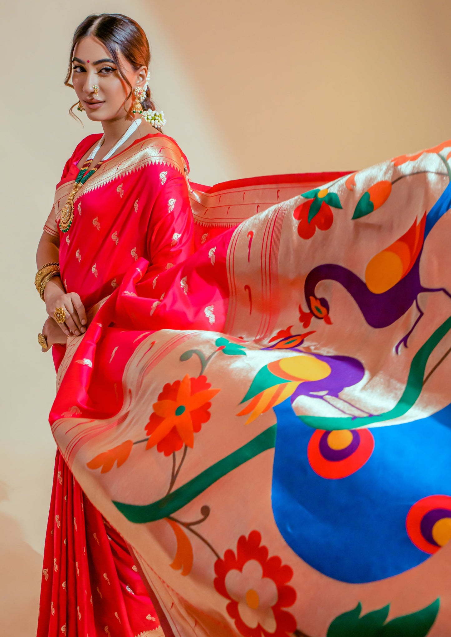 Woman showcasing pure paithani silk red handloom bridal saree pallu design usa.