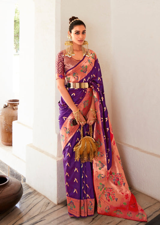 woman standing in Pure Paithani Silk Violet Purple Bridal Saree holding a mustard color handbag in front of a white wall.
