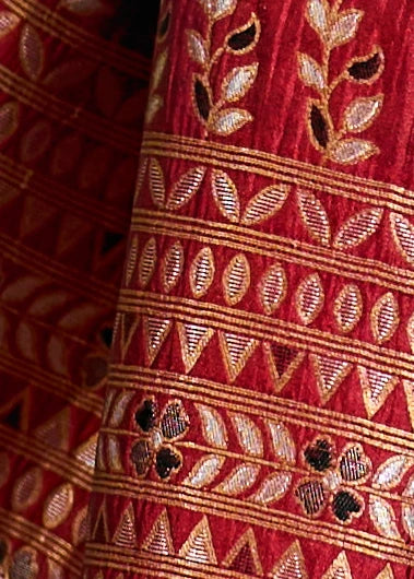 Close-up of red bridal silk saree in norway with gold zari work and black meenakari embroidery.