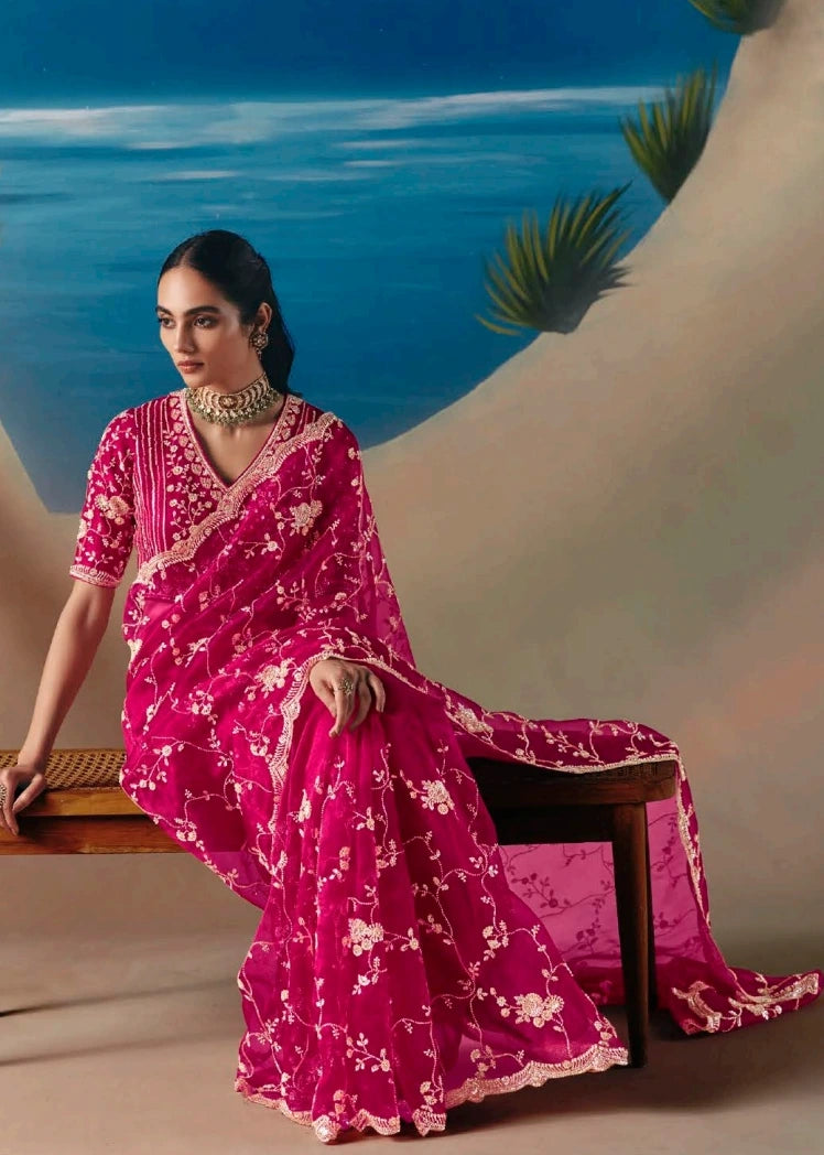 Designer pinkish red organza tissue silk saree with luminous sequin and bead hand embroidery for bridal trousseau and festive wedding wear.