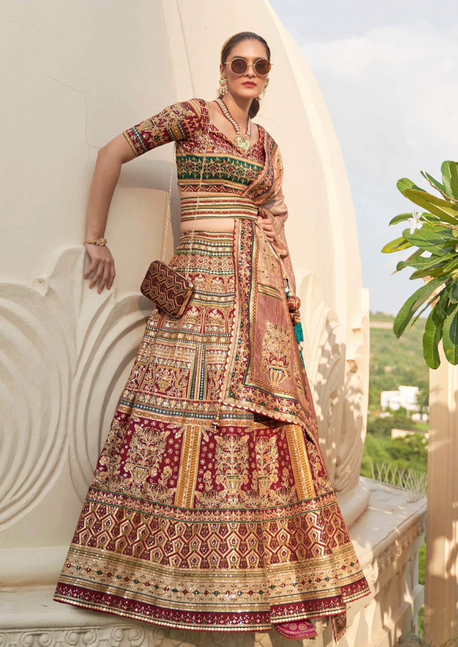 woman in bride in red and green lehenga choli with dupatta