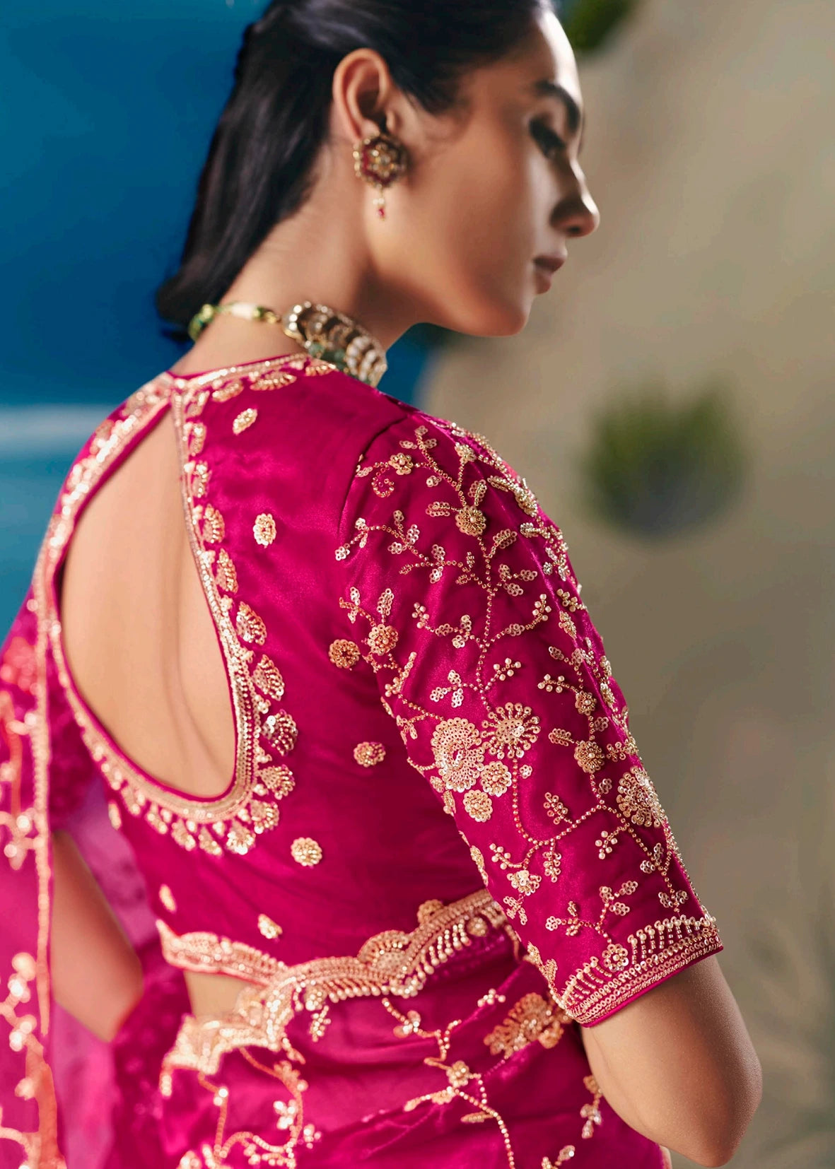 Pinkish red organza tissue silk bridal saree & matching embroidered blouse with deep back cut design featuring intricate beadwork and sequin detailing for wedding or engagement look.