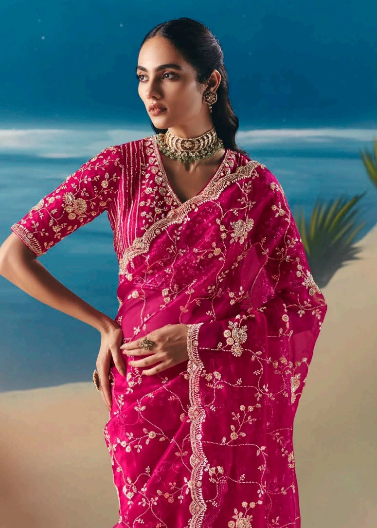 Sheer pinkish red organza tissue silk bridal saree featuring intricate hand beadwork and sparkling sequins embroidery on lightweight fabric.