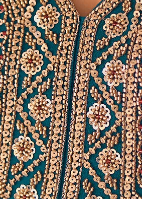 Close-up of a teal blue embroidered anarkali bodice featuring intricate gold sequins, beadwork, and floral patterns.