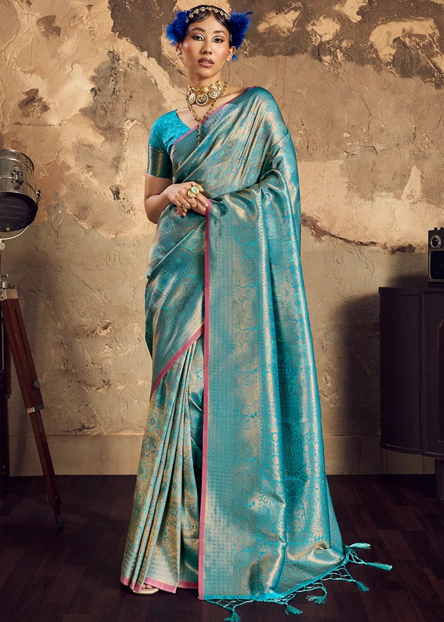 Full-length view of a turquoise blue Banarasi silk saree with all-over gold zari weaving.