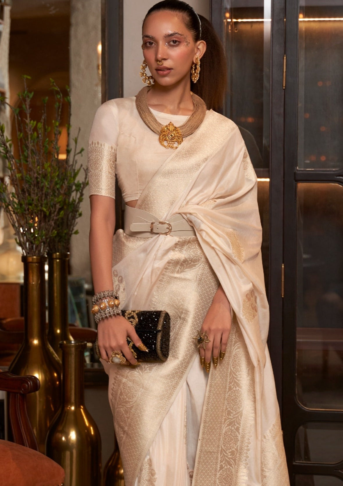 Woman in white khaddi georgette banarasi saree blouse with silver & golden zari work.