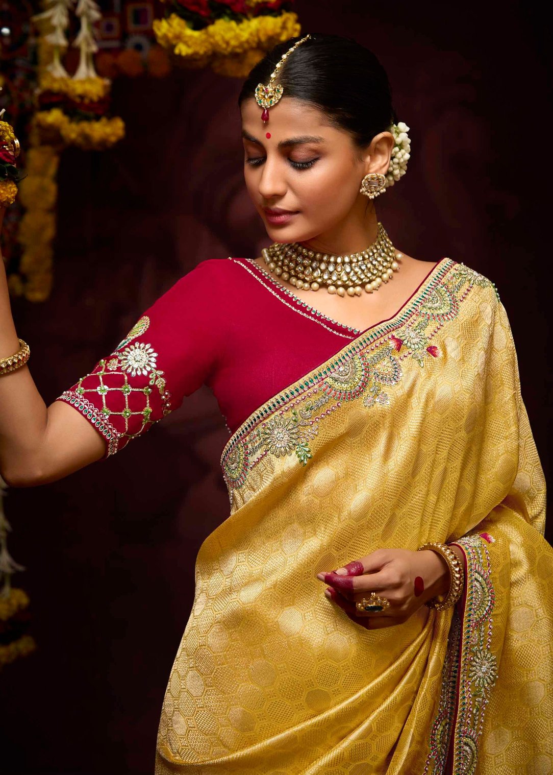 Yellow banarasi silk saree with contrast red blouse with hand embroidery work.