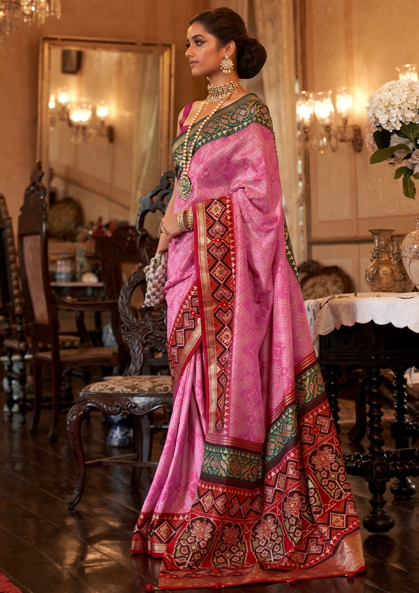 Bride in double ikkat patola and bandhani fusion pink saree.