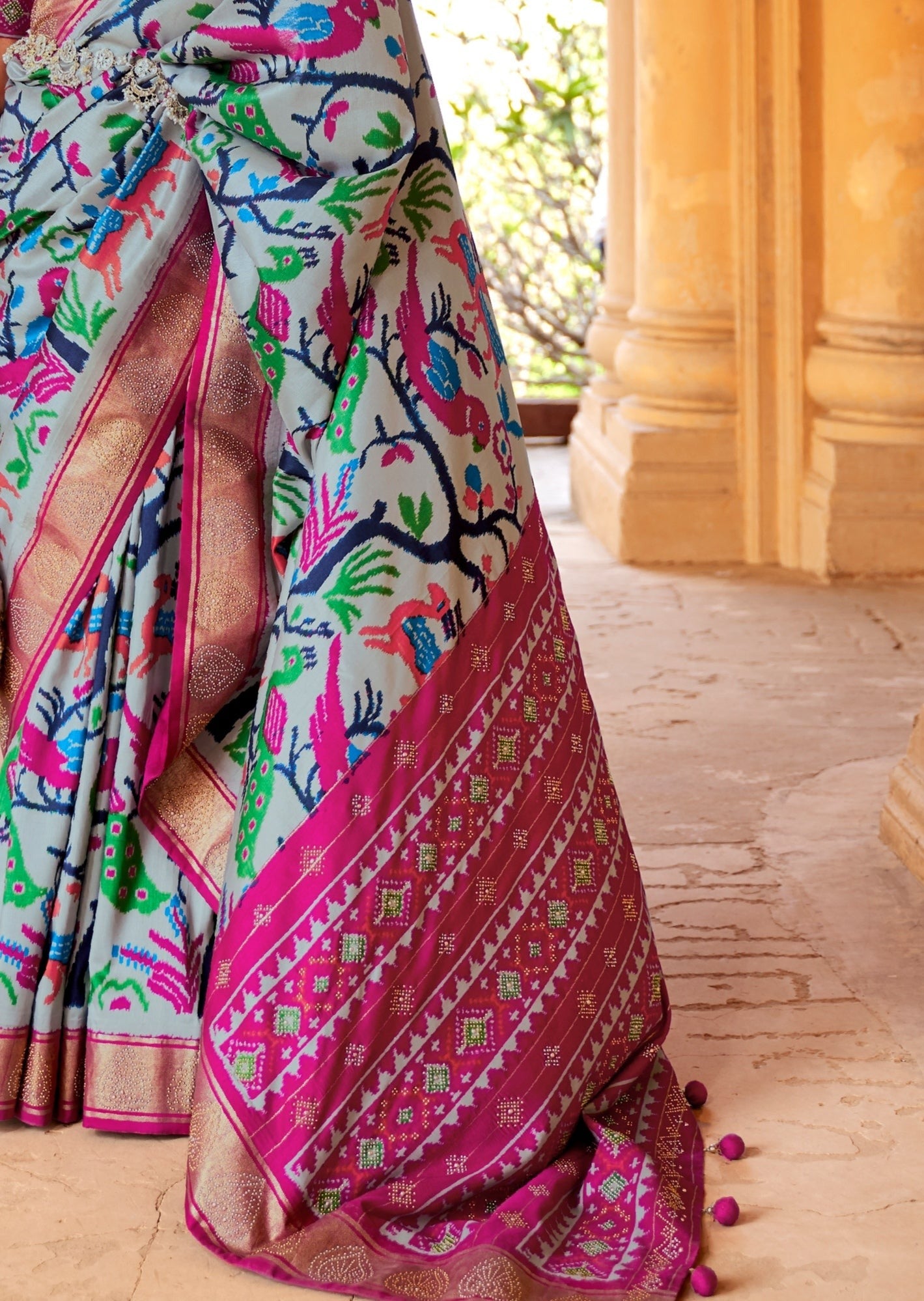 Grey patola silk saree online design with pink border and gold zari weaving work.