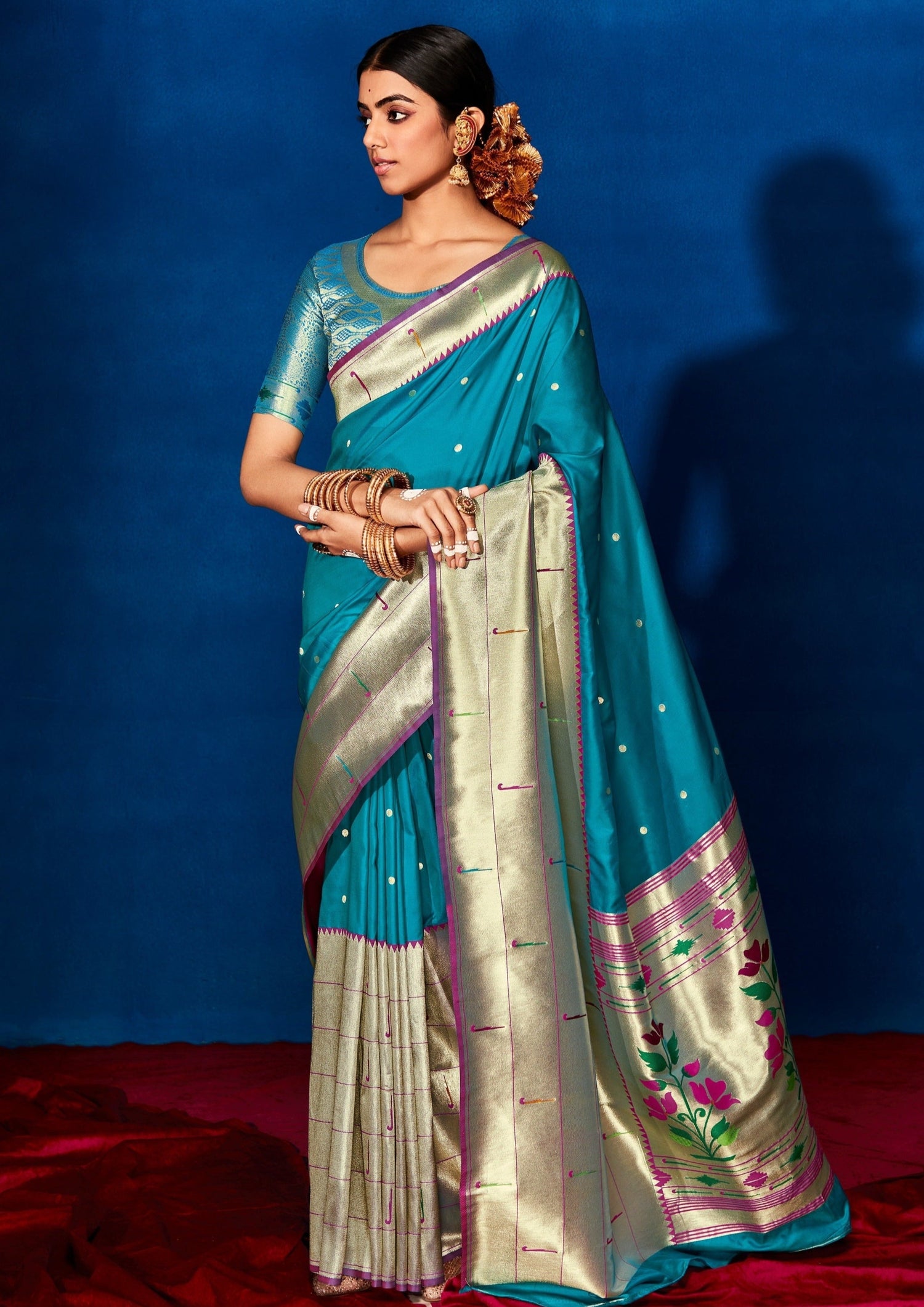 Woman standing in blue paithani saree blouse online shopping.
