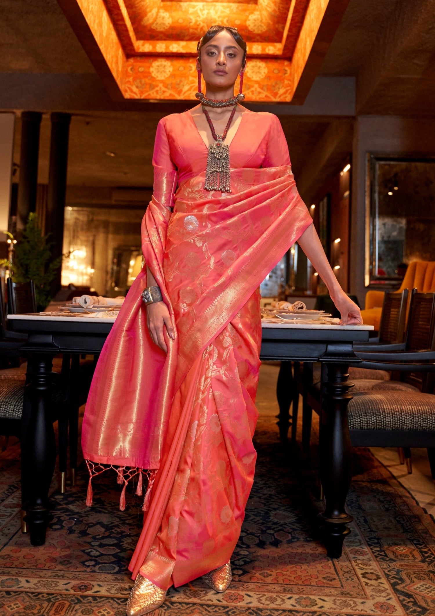 Handloom silk banarasi saree online in peach colour featuring traditional gold zari weaving border.