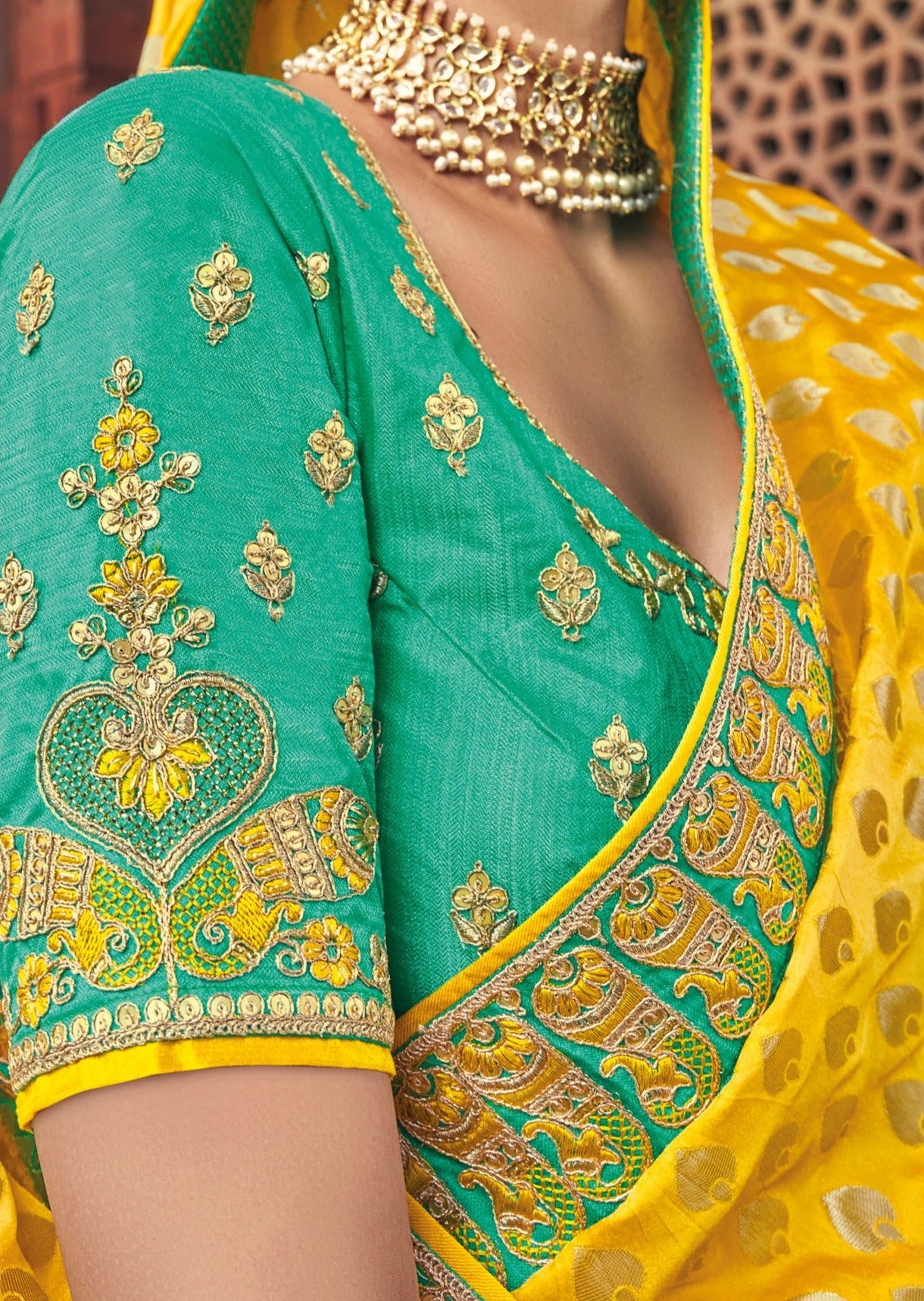 Luxury bridal banarasi silk yellow saree & green blouse with hand embroidery and zari details for traditional Indian bride.