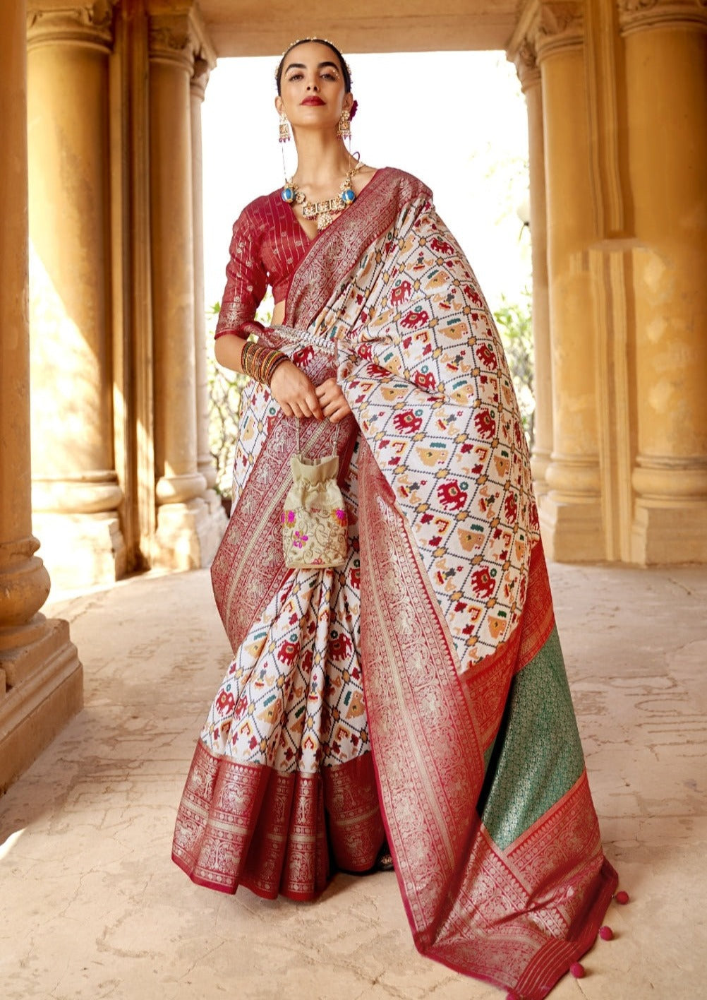 Patola saree online original in white color base, red zari border and green banarasi pallu featuring traditional hathi popat design.