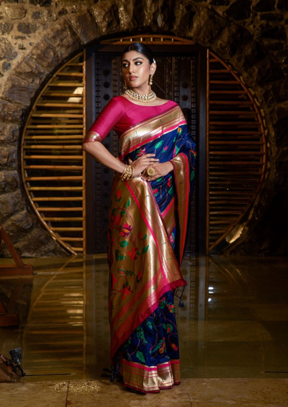 woman in royal blue paithani saree and pink blouse looking towards right