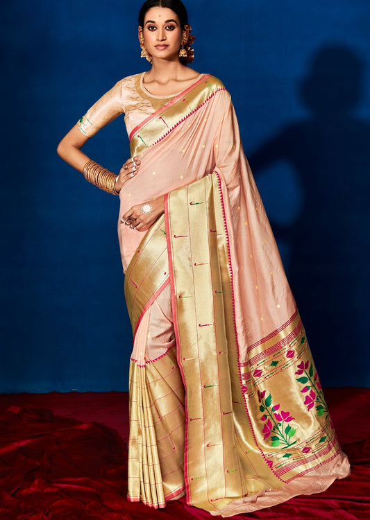 Woman standing in peach silk saree in front of blue wall