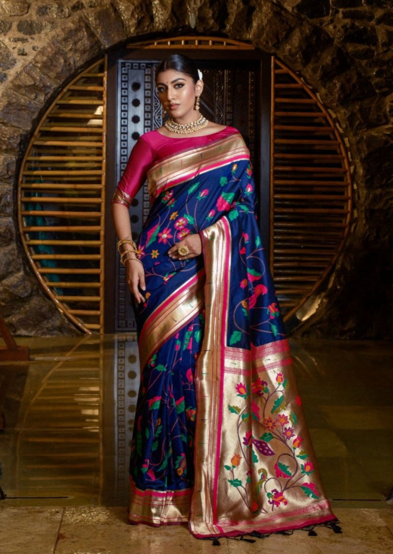woman standing in royal blue paithani saree and pink blouse
