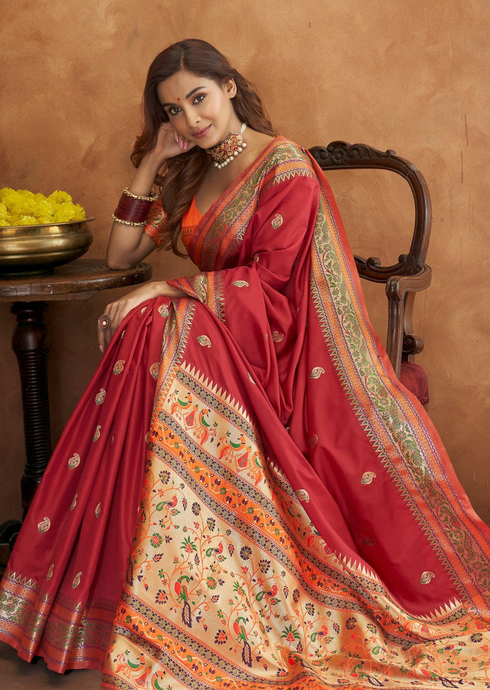 Red paithani saree with orange blouse featuring traditional design with zari border.